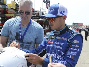 NASCAR driver Kyle Larson signs autographs after practice for the NASCAR Cup Series auto race in Brooklyn, Mich., Fruday, June 8, 2018.