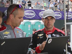 Will Power, right, talks with crew members after a practice session, Friday, June 1, 2018, for the IndyCar Detroit Grand Prix auto racing doubleheader on Belle Isle in Detroit this weekend.