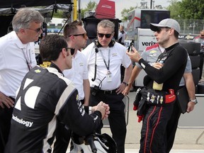 Team Penske drivers Will Power, right, and Simon Pagenaud talk with Chevrolet engineers after a practice session, Friday, June 1, 2018 for the IndyCar Detroit Grand Prix auto racing doubleheader on Belle Isle in Detroit this weekend.