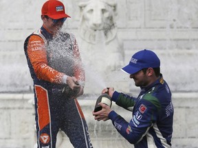 Alexander Rossi, right, sprays Scott Dixon after the first race of the IndyCar Detroit Grand Prix auto racing doubleheader, Saturday, June 2, 2018, in Detroit. Dixon won, and Rossie was third.