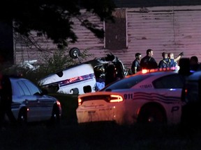 In this June 24, 2018 photo, Detroit police and fire department personnel work at the scene of a small plane crash in Detroit. Detroit police Capt. Mark Thornton told reporters the single-engine plane en route to Coleman A. Young International Airport apparently struck a power line and tree Sunday night.