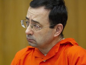 FILE - In this Jan. 31, 2018, file photo, Larry Nassar appears for his sentencing at Eaton County Circuit Court in Charlotte, Mich.  A letter signed by at least 120 victims sexual abuse by former sports doctor Nassar on Tuesday, June 19, urged Michigan State University's governing board to oust interim president John Engler, saying he had reinforced a "culture of abuse" at the school.