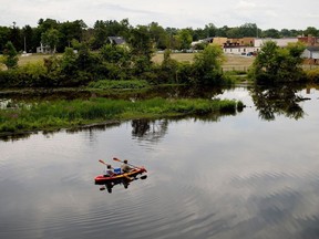 FILE- In this Aug. 14, 2017 file photo, a couple kayak on the Rogue River adjacent to where Wolverine World Wide's tannery once stood, in Rockford, Mich. The Michigan Department of Environmental Quality is investigating the connection between old waste drums in the area and an old Wolverine World Wide tannery waste dump nearby. Some private wells in the area have tested positive for elevated levels of per- and polyfluoroalkyl substances called PFAS, also called perfluorinated chemicals, or PFCs. A government report shows that a family of industrial chemicals turning up in public water supplies around the country threatens human health at concentrations seven to 10 times lower than previously realized. The chemicals are called perfluoroalkyl and polyfluoroalkyl.