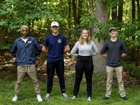 In this Wednesday, June 6, 2018 photo, from left, Yoel, Bryce, Rose and Mason Lee stand at attention outside their home in Ada, Mich. Yoel and his siblings, who are also quadruplets (Nevin is not pictured) are all planning on joining the military.