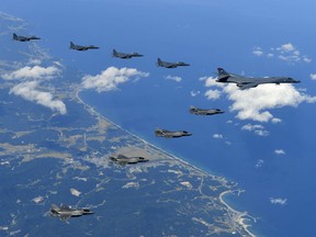 In this file photo Sept. 18, 2017 provided by South Korea Defense Ministry, U.S. Air Force B-1B bomber, F-35B stealth fighter jets and South Korean F-15K fighter jets fly over the Korean Peninsula during a joint drills, South Korea. The Pentagon on Monday, June 18, 2018, formally suspended a major military exercise planned for August with South Korea, a much-anticipated move stemming from President Donald Trump's nuclear summit with North Korean leader Kim Jong Un.