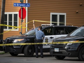Police investigate the scene of an officer-involved shooting Saturday, June 23, 2018, in Minneapolis. Police in Minneapolis say officers shot and killed a man who was firing a handgun as he walked down a city street.