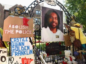FILE - In this July 24, 2016, file photo, a photo of Philando Castile hangs on the gate of the governor's residence in St. Paul, Minn., as protesters demonstrate against the July 2016, shooting death of Castile by a St. Anthony police officer making a traffic stop in Falcon Heights, Mich. The St. Anthony Police Department announced new goals, Thursday, June 14, 2018, to help rebuild community trust following Castile's death.