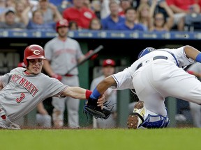Cincinnati Reds' Scooter Gennett (3) is tagged out at home by Kansas City Royals catcher Salvador Perez as he tried to score on a fly-out by Jose Peraza during the second inning of a baseball game Tuesday, June 12, 2018, in Kansas City, Mo.