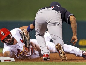 St. Louis Cardinals' Matt Carpenter is tagged out by Cleveland Indians third baseman Jose Ramirez, right, while trying to reach third base during the first inning of a baseball game Monday, June 25, 2018, in St. Louis.