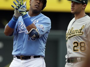 Kansas City Royals catcher Salvador Perez, left, celebrates his two-run double while next to Oakland Athletics' Matt Olson (28) during the first inning of a baseball game at Kauffman Stadium in Kansas City, Mo., Saturday, June 2, 2018.