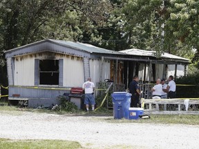 Investigators look over the remains of a deadly fire, Wednesday, June 6, 2018,  in Lebanon, Mo. Authorities say five children were killed and a woman injured in the mobile home fire in southern Missouri.