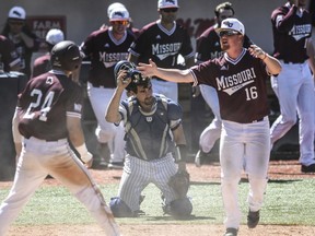 Saint Louis catcher James Morisano, center, takes off his mask as Missouri State pitcher Jake Fromson (16) and catcher Drew Millas (24) celebrate their win in the NCAA college Oxford Regional baseball game in Oxford, Miss., Sunday, June 3, 2018.