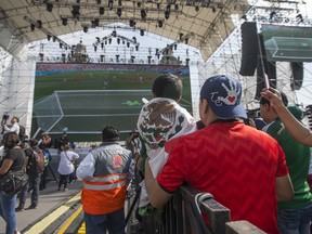 Mexico fans  watch a live telecast of the Mexico vs. Korea World Cup soccer match in Mexico City's Zocalo, Sunday, June 23, 2018. (AP Photo/Christian Palma)