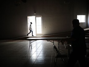 In this May 6, 2018 photo, 26-year-old Pierre Franzzi walks through the communal dining room during a religious service inside the Ambassadors of Jesus Church next to Little Haiti, in Tijuana, Mexico. Since the arrival of hundreds of Central American migrants, Franzzi says that his case is not a priority anymore, which is one of the reasons he is planning to return back to Haiti.