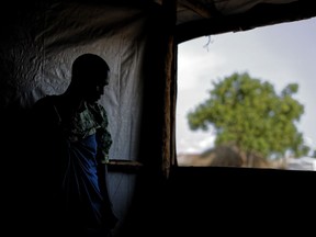 FILE - In this Saturday, June 3, 2017 file photo, a South Sudanese refugee and 32-year-old mother, who was raped for several days by a group of soldiers before she was allowed to leave, stands by a window at a women's center focusing on gender-based violence, run by the aid group International Rescue Committee, in Bidi Bidi, Uganda. Atrocities have been revealed in 14 reports, seen by The Associated Press, that are yet to be released as of Wednesday, June 6, 2018 by the independent body charged with monitoring a failed cease-fire imposed in December.