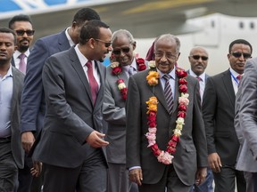 Eritrea's Foreign Minister Osman Sale, center right, is welcomed by Ethiopia's Prime Minister Abiy Ahmed, center left, upon the Eritrean delegation's arrival at the airport in Addis Ababa, Ethiopia Tuesday, June 26, 2018. The delegation of top officials from Eritrea arrived Tuesday in Ethiopia for the first peace talks in 20 years and were welcomed at the airport by Ethiopian Prime Minister Abiy Ahmed, signifying the importance of their visit.