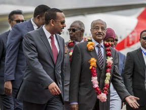 Eritrea's Foreign Minister Osman Sale, center-right, is welcomed by Ethiopia's Prime Minister Abiy Ahmed, center-left, upon the Eritrean delegation's arrival at the airport in Addis Ababa, Ethiopia Tuesday, June 26, 2018. The delegation of top officials from Eritrea arrived Tuesday for the first peace talks in 20 years and were welcomed at the airport by Ethiopian Prime Minister Abiy Ahmed, signifying the importance of their visit.