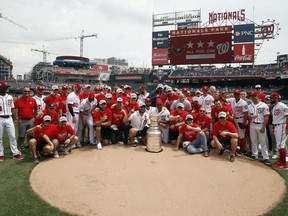 The Washington Capitals and the Washington Nationals pose for a group photo on the field with the Stanley Cup before a baseball game between the Nationals and the San Francisco Giants at Nationals Park, Saturday, June 9, 2018, in Washington.