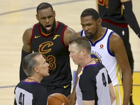 Cleveland Cavaliers forward LeBron James, top left, and Golden State Warriors forward Kevin Durant, top right, talk with officials during the second half of Game 1 of the NBA Finals on Thursday, May 31, 2018.