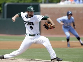 Stetson pitcher Jack Perkins winds up to deliver a pitch during the first inning of an NCAA super regional college baseball game against North Carolina in Chapel Hill, N.C., Saturday, June 9, 2018.