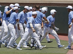North Carolina's Cody Roberts, second from right, is congratulated by teammates following his homer against Stetson in the fifth inning of an NCAA super regional college baseball game in Chapel Hill, N.C., Friday, June 8, 2018. North Carolina won 7-4.