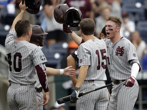 Mississippi State designated hitter Jordan Westburg, right, celebrates his grand slam with Jake Mangum (15) and teammates in the second inning of an NCAA College World Series baseball game against North Carolina in Omaha, Neb., Tuesday, June 19, 2018.