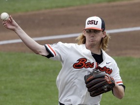 Oregon State pitcher Bryce Fehmel throws to first on a pickoff-attempt in the first inning of an NCAA College World Series baseball game against Mississippi State in Omaha, Neb., Friday, June 22, 2018.