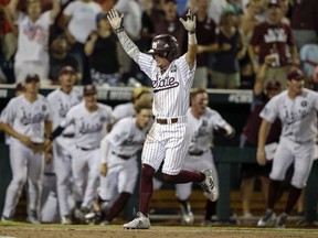 Mississippi State's Hunter Stovall, center, celebrates as he runs to home plate for the winning run against Washington on a single by Luke Alexander in the ninth inning of an NCAA College World Series baseball game in Omaha, Neb., Saturday, June 16, 2018.
