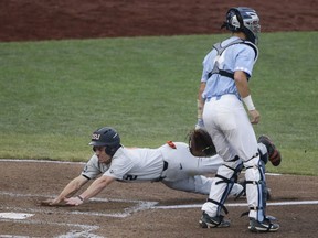 Oregon State's Cadyn Grenier slides home as North Carolina catcher Brandon Martorano (4) waits for the throw on a double by Trevor Larnach (11) in the third inning of an NCAA College World Series baseball elimination game in Omaha, Neb., Wednesday, June 20, 2018.