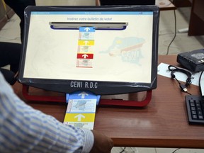 In this photo taken Thursday March 15, 2018, a man demonstrates using an electronic voting machine that will be used later in the year for the next election, in Kinshasa, Democratic Republic of Congo. Congo's government is moving forward with plans to use electronic voting machines in this year's highly anticipated presidential election despite warnings from watchdog groups that transparency and credibility could suffer.