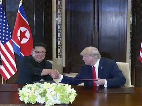 In this image made from video released by KRT on June 14, 2018, shows North Korean leader Kim Jong Un smiling at the media as he shakes hands with U.S. President Donald Trump.
