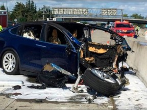 FILE - In this March 23, 2018, file photo provided by KTVU, emergency personnel work at the scene where a Tesla electric SUV crashed into a barrier on U.S. Highway 101 in Mountain View, Calif. Federal investigators say the Tesla using the company's semi-autonomous driving system accelerated just before crashing into a California freeway barrier, killing its driver. The National Transportation Safety Board issued a preliminary report on the crash on Thursday, June 7. (KTVU via AP, File)