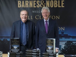 FILE - In this June 5, 2018 file photo, former President Bill Clinton, right, and author James Patterson pose for photographers during an event to promote their new novel, "The President is Missing," in New York. Clinton's debut as a novelist is already one of the year's biggest hits. "The President is Missing," the thriller he co-wrote with James Patterson, sold 250,000 copies its first week. Alfred A. Knopf and Little, Brown and Co., the book's co-publishers, announced Wednesday, June 13 that the number includes hardcover, e-book and audio sales.