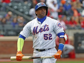FILE - In this Sunday, April 1, 2018 file photo, New York Mets Yoenis Cespedes (52) holds his broken bat as he looks at a video replay of his flyout to deep left field during the third inning of a baseball game against the St. Louis Cardinals in New York. Yoenis Cespedes' rehab assignment has been cut short after a setback, and the plummeting New York Mets aren't sure when they might get their slugging left fielder back from a nagging hip injury, Sunday, June 10, 2018.