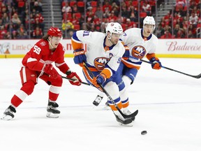 FILE - In this April 7, 2018, file photo, New York Islanders center John Tavares (91) carries the puck against the Detroit Red Wings during the first period of an NHL hockey game in Detroit. As the No. 1 pending free agent, Tavares not only gets to hand out his rose like hockey's version of "The Bachelor" but can set the tone for the rest of the players available. He can only get an eight-year contract from the Islanders--unless they execute a sign-and-trade to recoup some value--and could very well become the league's second-highest-paid player behind Edmonton Oilers captain Connor McDavid, who makes an average of $12.5 million a season.