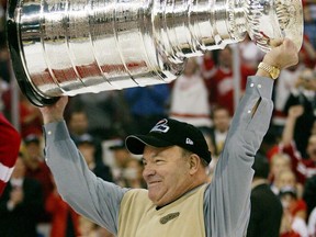 FILE - In this June 3, 2002, file photo, Detroit Red Wings coach Scotty Bowman holds the Stanley Cup after Red Wings defeated the Carolina Hurricanes 3-1 in Detroit. Dave Lewis succeeded Bowman after being his associate coach with the champion 2002 Detroit Red Wings, and Bowman stepped in for "Badger" Bob Johnson after he led the Pittsburgh Penguins to the Cup in 1991 and had to take a leave of absence to fight cancer. All three had to balance the excitement of running a team with the expectations of following a Cup-winning coach and the pressure that came with it.