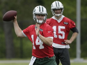 FILE - In this May 22, 2018, file photo, New York Jets quarterback Josh McCown, right, watches as quarterback Sam Darnold throws during practice at the NFL football team's training camp in Florham Park, N.J. Darnold and Josh Allen are spending their weekend watching greatness, and for once it's not other football players. They're at Shinnecock Hills for the U.S. Open golf tournament.