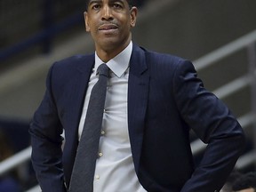 FILE - In this Feb. 7, 2018, file photo, then-Connecticut head coach Kevin Ollie watches the first half an NCAA college basketball game, in Storrs, Conn. The University of Connecticut says it fired men's basketball coach Kevin Ollie after finding NCAA violations that included improper workouts and improper contact with recruits by Ollie and former UConn star Ray Allen. In a statement to The Associated Press on Thursday, June 21, 2018, Ollie's lawyer Jacques Parenteau called the infractions cited by UConn in firing Ollie minimal and isolated. He also says they fail to justify withholding the more than $10 million they believe Ollie is owed under his contract.