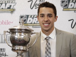 FILE - In this June 21, 2017, file photo, Johnny Gaudreau of the Calgary Flames poses with the Lady Byng Memorial Trophy after winning the honor during the NHL Awards show in Las Vegas. "Johnny Hockey" is getting an additional title: part owner. Calgary Flames star forward Johnny Gaudreau is a member of an NHL-laden ownership group that purchased an equity stake in the U.S. Hockey League's Dubuque Fighting Saints on Thursday, June 21, 2018.