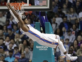 FILE - In this Jan. 13, 2018, file photo, Oklahoma City Thunder's Paul George (13) hangs from the rim after a dunk against the Charlotte Hornets during the first half of an NBA basketball game in Charlotte, N.C. An NBA free-agent class with a little something for everyone hits the market on July 1. The group includes an array of superstars, big men, glue guys and sharp-shooters.