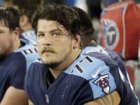 FILE - In this Oct. 16, 2017, file photo, Tennessee Titans' Taylor Lewan sits on the bench during the first half of an NFL football game against the Indianapolis Colts in Nashville, Tenn. The two-time Pro Bowler is skipping the team's mandatory minicamp. The team issued a statement just before the first practice from the general manager saying Lewan's representatives told the team he would not be at camp.