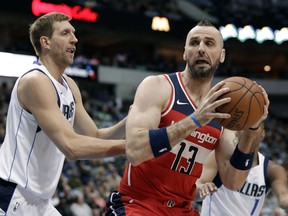 FILE - In this Jan. 22, 2018, file photo, Dallas Mavericks forward Dirk Nowitzki (41) defends against Washington Wizards center Marcin Gortat during the first half of an NBA basketball game in Dallas. A person familiar with the deal says that the Wizards have agreed to trade Gortat to the Los Angeles Clippers for guard Austin Rivers.