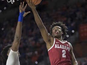 FILE - In this Feb. 3, 2018, file photo, Alabama guard Collin Sexton (2) drives to the basket over Florida forward Dontay Bassett (21) during the first half of an NCAA college basketball game in Gainesville, Fla. Sexton is a possible pick in Thursday's NBA Draft.