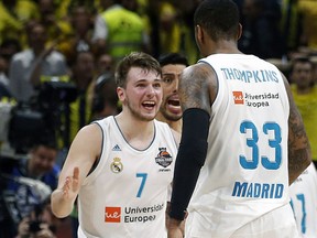 FILE - In this May 20, 2018, file photo, Real Madrid's Luka Doncic (7) reacts with teammate Trey Thompkins after winning their Final Four Euroleague final basketball match against Fenerbahce, in Belgrade, Serbia. The Slovenian guard heads the list of international players expected to be selected in the NBA draft.