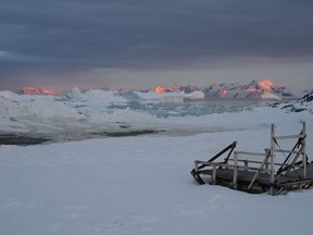 In this 2011 photo provided by researcher Hamish Pritchard, the late summer sun sets over mountains and icebergs around Adelaide Island off the Antarctic Peninsula, as twenty-four hour daylight gives way to the long polar night of winter. In a study released Wednesday, June 13, 2018, an international team of ice experts said the melting of Antarctica is accelerating at an alarming rate, with about 3 trillion tons of ice disappearing since 1992.