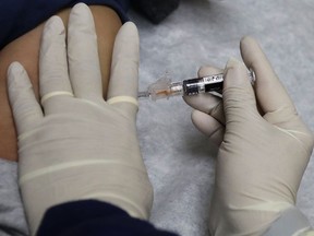 FILE - In this Jan. 12, 2018, file photo, a medical assistant at a community health center gives a patient a flu shot in Seattle. A newer kind of flu vaccine worked a little bit better in seniors this past winter than traditional shots, the government reported Wednesday, June 20, 2018.