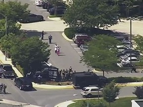 In this frame from video, people leave the Capital Gazette newspaper after multiple people have been shot on Thursday, June 28, 2018, in Annapolis, Md. (WJLA via AP)