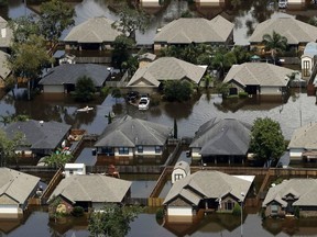 FILE - In this Friday, Sept. 1, 2017 file photo, homes are surrounded by water from the flooded Brazos River in the aftermath of Hurricane Harvey in Freeport, Texas. According to a study released on Wednesday, June 6, 2018, tropical cyclones around the world are moving slightly slower over land and water, dumping more rain as they stall, just as Hurricane Harvey did.