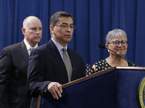 FILE - In this May 1, 2018, file photo, California Attorney General Xavier Becerra, center, speaks during a news conference in Sacramento, Calif. Insurance Commissioner Dave Jones has said he, too, would be eager to challenge President Donald Trump policies but says Becerra has been so focused on Trump that he is not doing enough on other issues, such as the opioid epidemic, gun violence and going after corporate polluters. Becerra says Jones is being deceptive, pointing to his office's prosecutions for illegal gun possession, sex trafficking, embezzlement and other offenses.