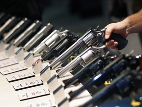 FILE - In this Jan. 19, 2016, file photo, handguns are displayed at a trade show in Las Vegas. A new study by the Small Arms Survey released Monday, June 18, 2018, of small arms estimates there are over 1 billion legal and illicit firearms in the world today, including 857 million in civilian hands -- with American men and women the dominant owners.